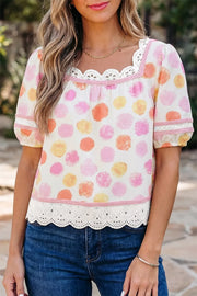 White polyester blouse with pink, orange, and yellow polka dots, puff sleeves, and lace trim.