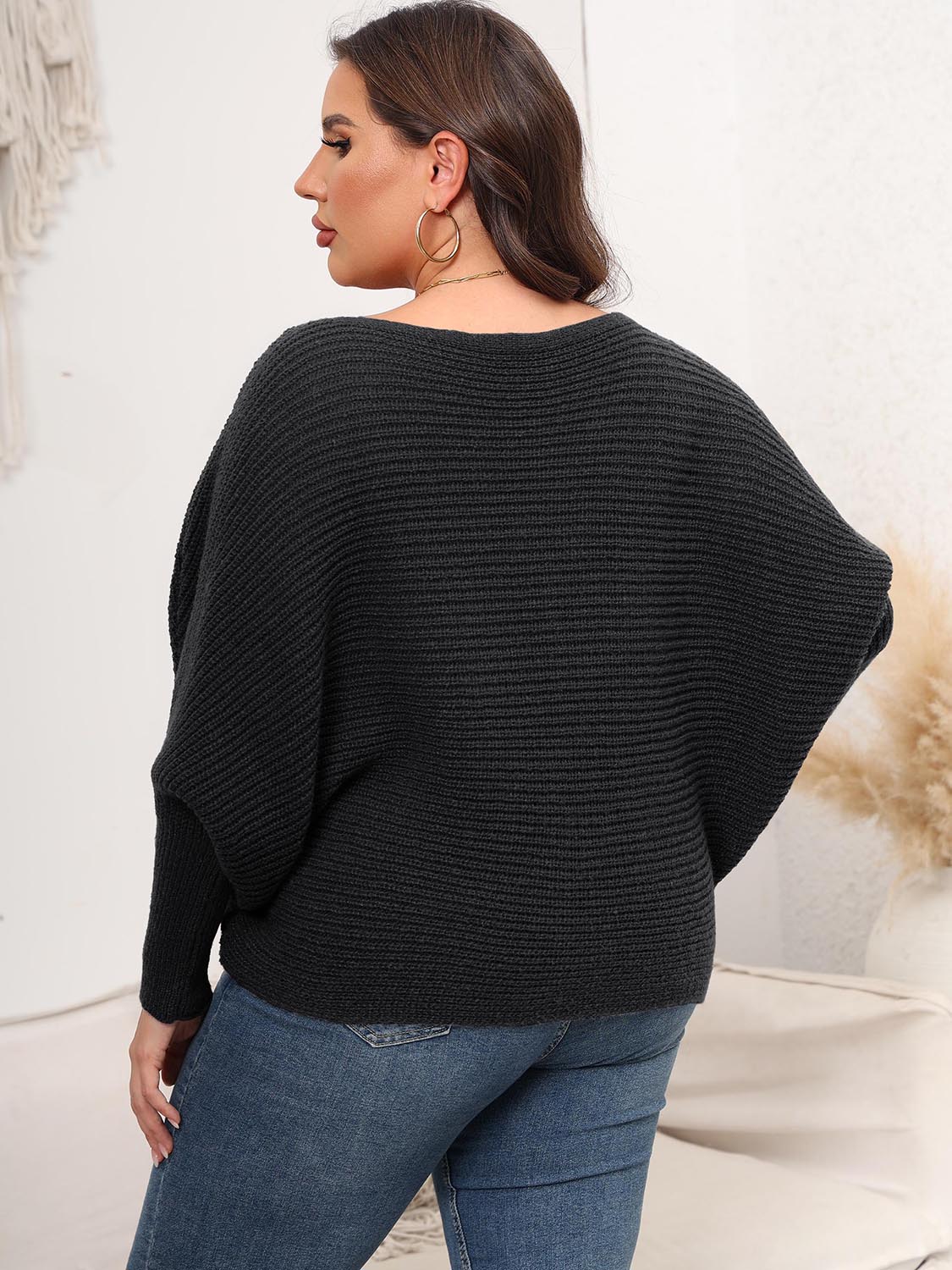 Charcoal ribbed knit sweater with batwing sleeves and a boat neckline.
