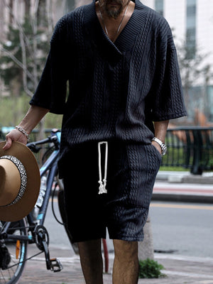 Black cable-knit V-neck two-piece set with short sleeves and drawstring shorts.