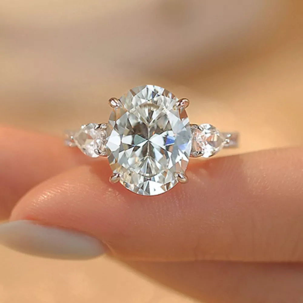 Sterling silver ring with a large oval moissanite and two pear-shaped side stones.