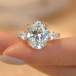 Sterling silver ring with a large oval moissanite and two pear-shaped side stones.