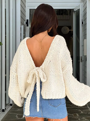 Cream textured tie-front knit cardigan with balloon sleeves and a deep V-back tied with a bow.