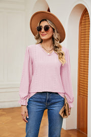 Pink perforated sleeve blouse with ruffle cuffs and V-neck.