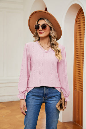 Pink perforated sleeve blouse with ruffle cuffs and V-neck.
