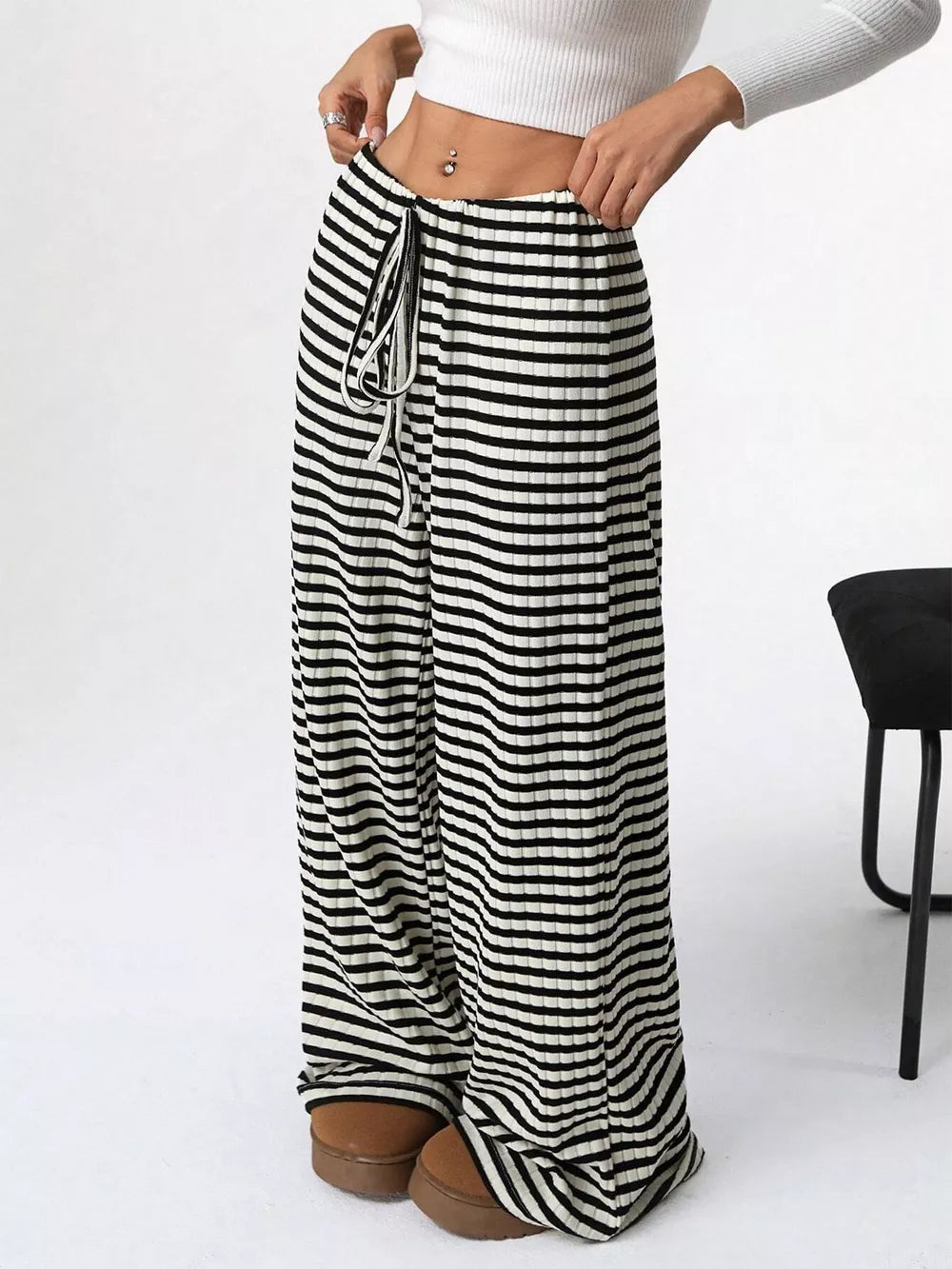 Striped ribbed wide-leg pants with drawstring waist and black and white horizontal stripes.