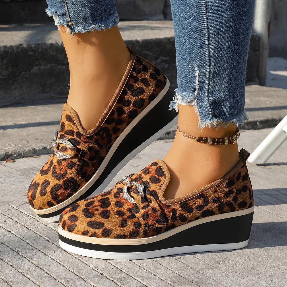 Leopard print wedge loafers with buckle detail in brown, featuring a platform sole.