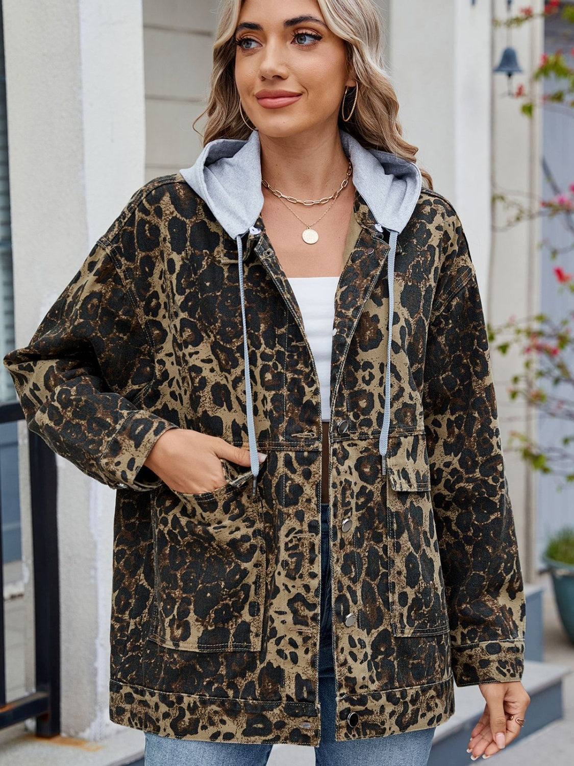 Leopard print denim jacket with a removable grey hooded lining and utility pockets.