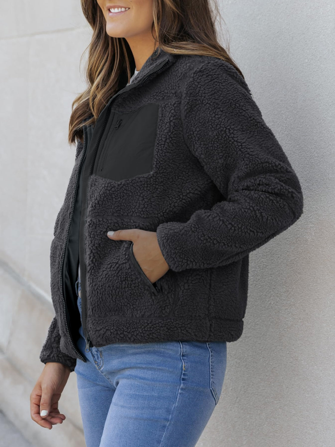 Sherpa zip-up jacket in dark gray with black patch pocket and side pockets.