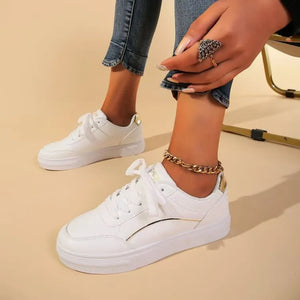 White sneakers with gold metallic trim and heel detail, lace-up closure.