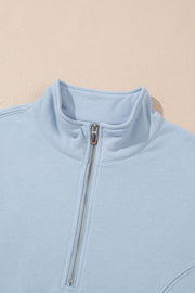 Light blue quarter-zip sweatshirt with a mock neck and silver zipper detail.