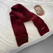 Textured red knit scarf with pockets and green embroidered logo