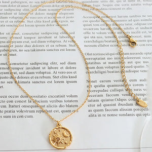 Gold coin necklace with sun and moon motif, chic celestial design.