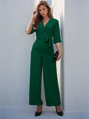 Dark green tailored wrap-front palazzo jumpsuit with tie waist and wide legs.