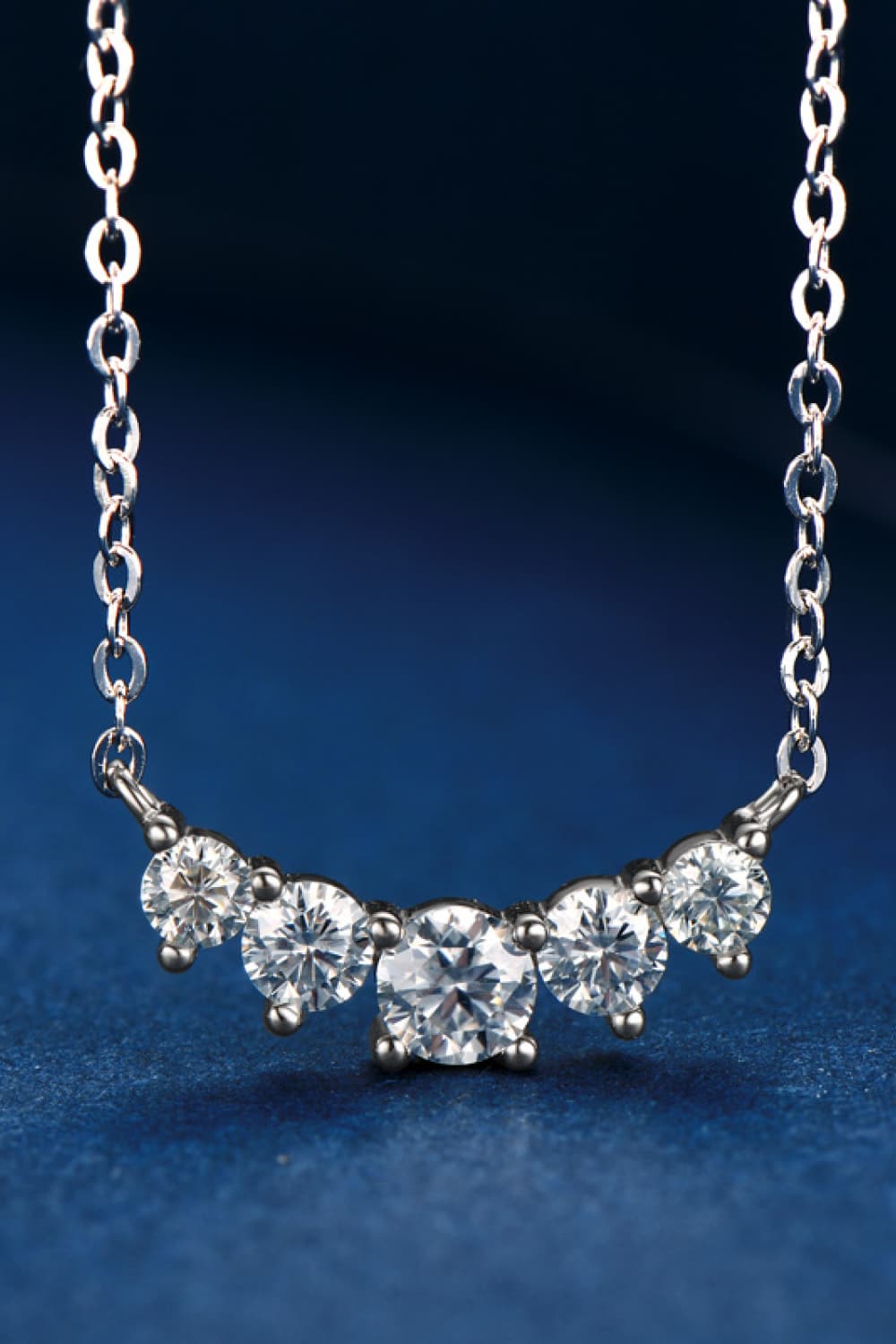 Celestial Arc Necklace in silver with five sparkling cubic zirconia stones on a delicate chain.