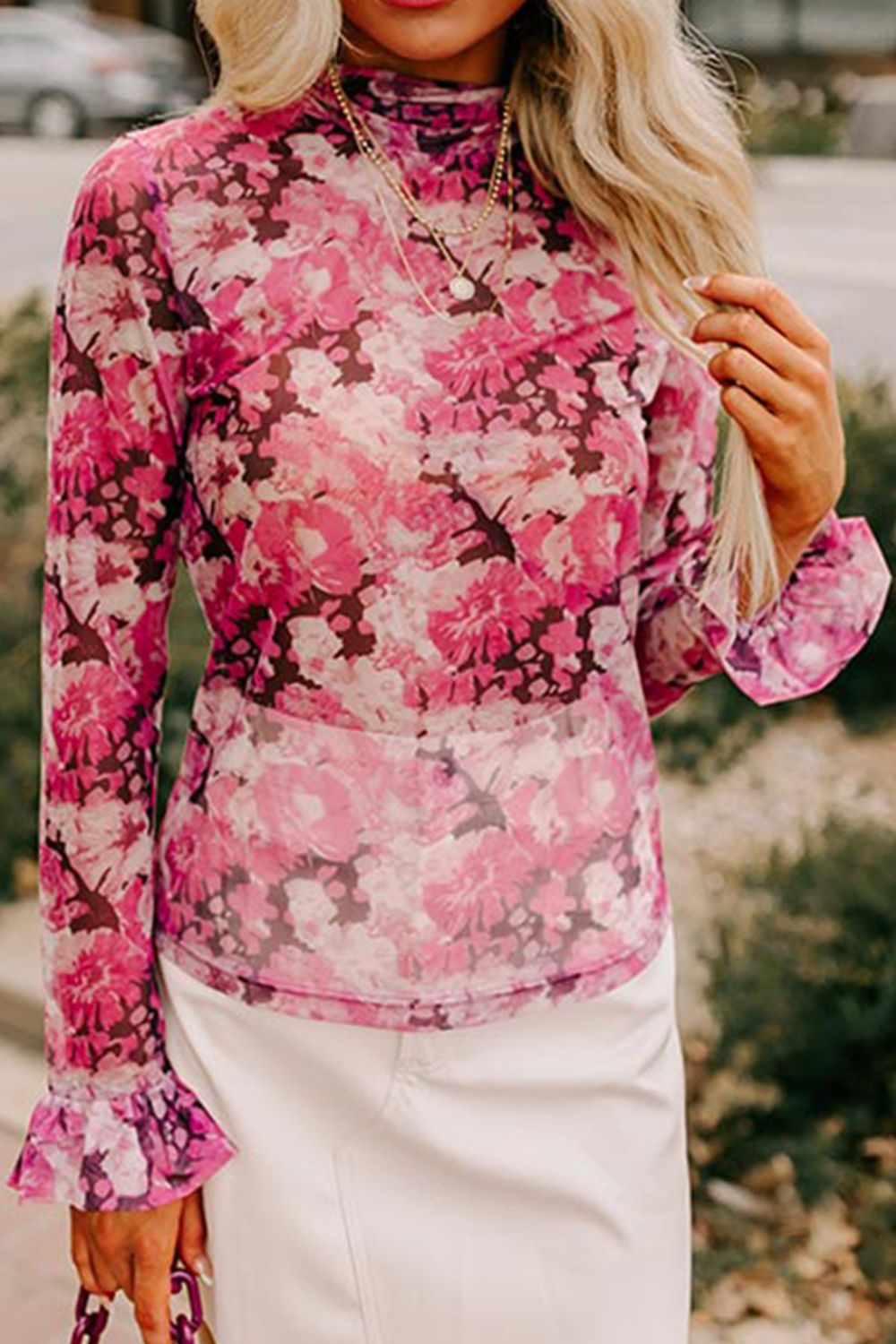 Pink sheer floral long sleeve blouse with ruffle cuffs and mock neck.