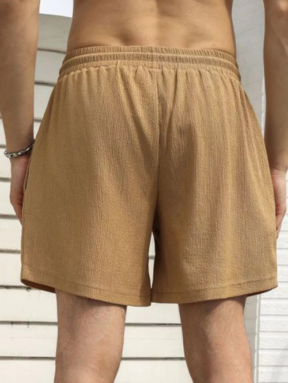 Men's khaki chino shorts with drawstring waist and textured fabric.
