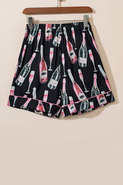 Black silk pajama shorts with champagne print and pink piping.