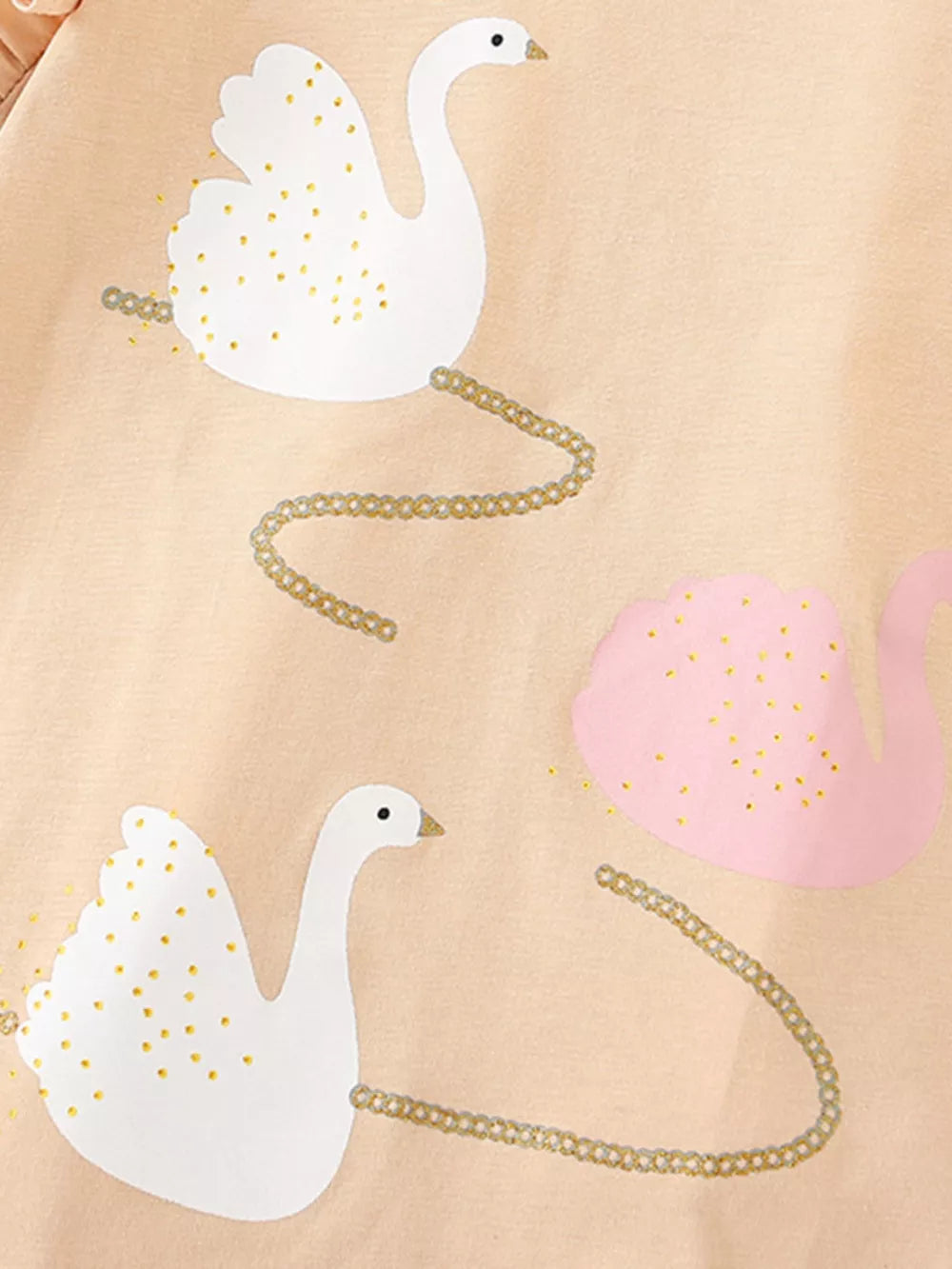 Girls' undershirt with white and pink swans and gold chain detail on peach cotton.