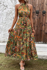 Halter neck maxi dress with a colorful paisley print and tiered skirt.