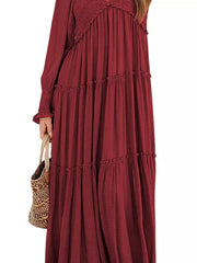 Wine red smocked v-neck tiered maxi dress with long sleeves and ruffled tiers.
