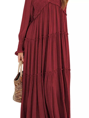 Wine red smocked v-neck tiered maxi dress with long sleeves and ruffled tiers.