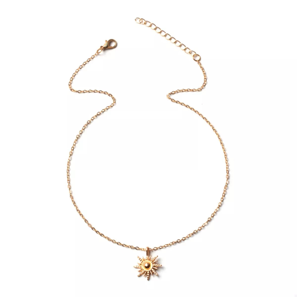 Gold sunburst pendant necklace with lace trim detail on a delicate chain.
