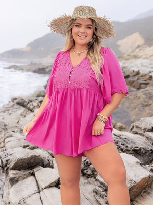 Hot pink eyelet yoke romper with flutter sleeves and v-neckline, styled with a straw hat.