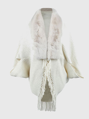 White textured knit poncho with faux fur collar and fringe detail