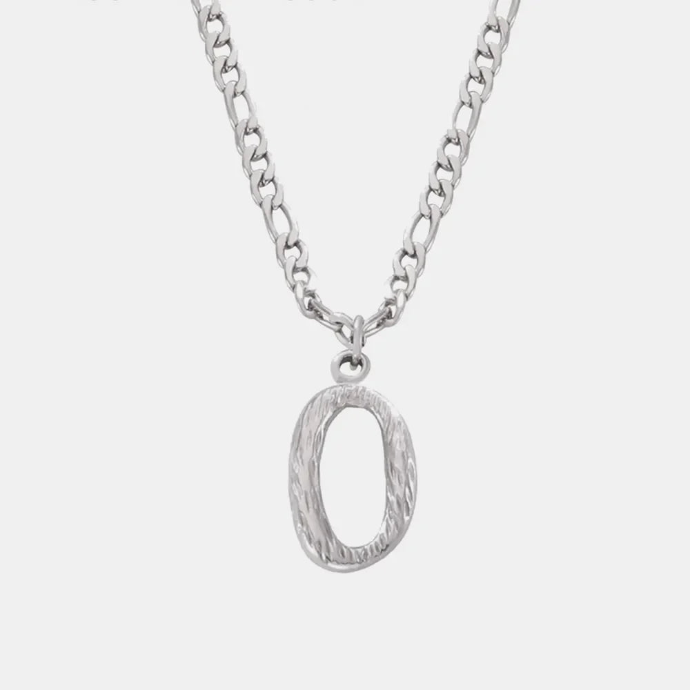 Textured initial pendant necklace in silver with a figaro chain.