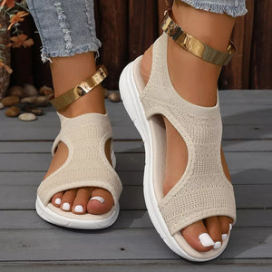 Beige knit open-toe platform sandals with white soles and gold ankle straps.