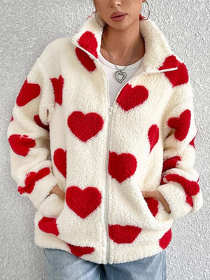 Heart print sherpa zip-up jacket with red hearts on cream fuzzy material.