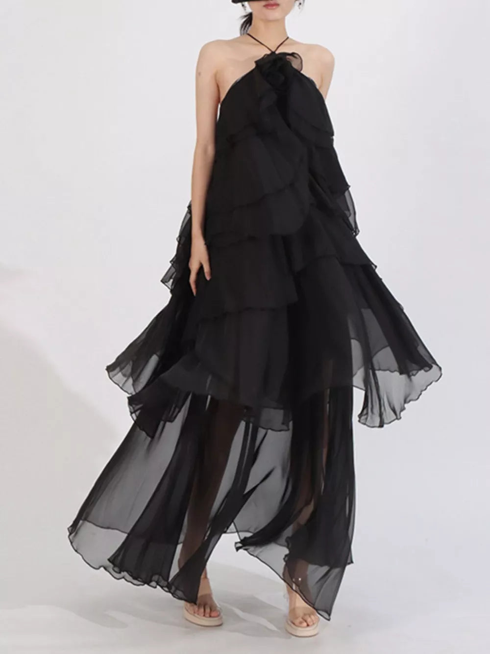 Black ruffle halter maxi dress with cascading tiers and sheer skirt.