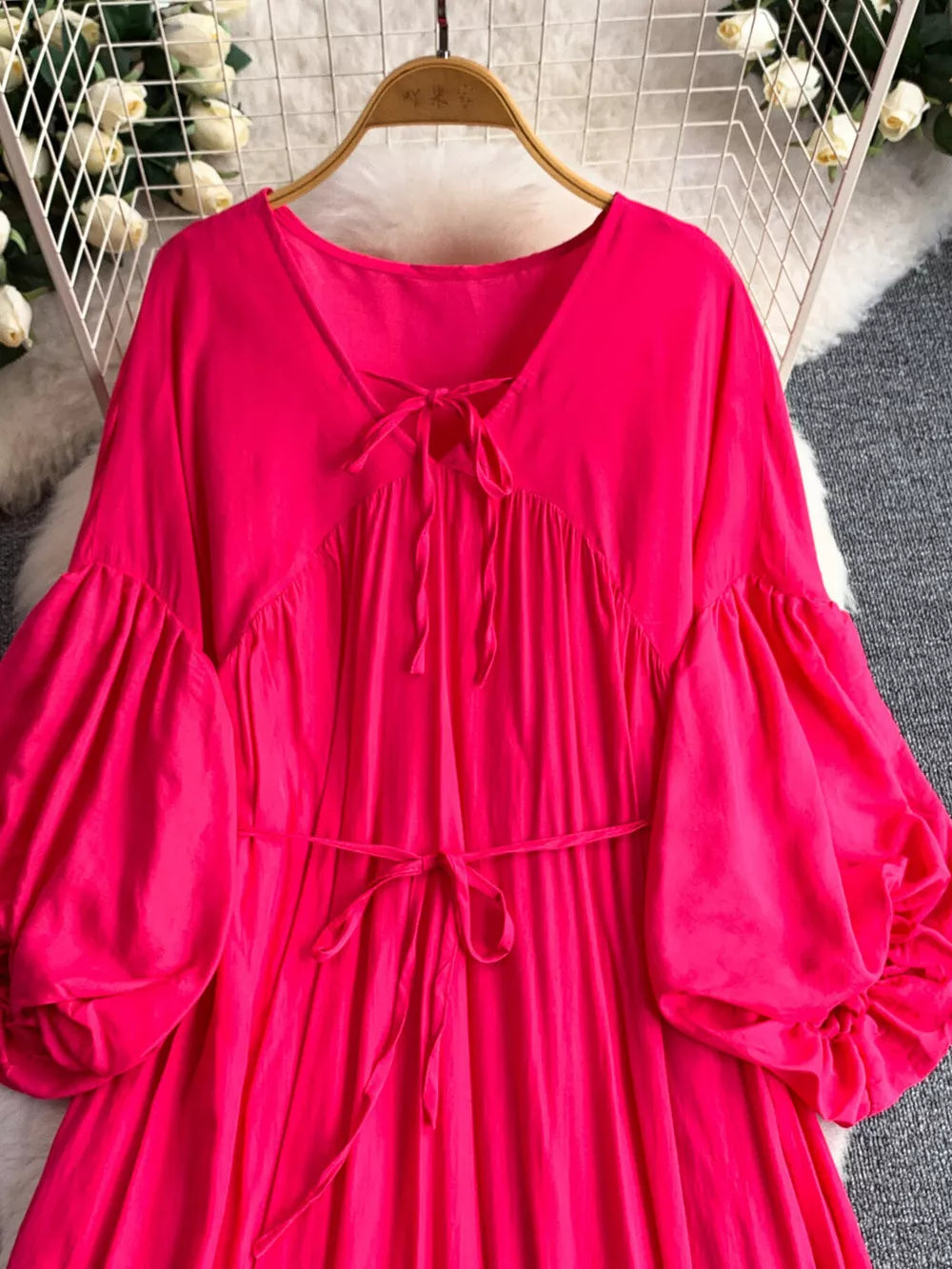 Fuchsia pink polyester maxi dress with balloon sleeves and tie neckline.