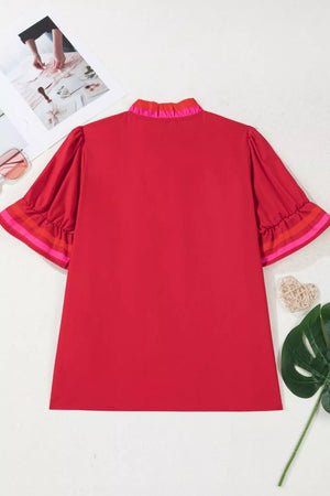 Red maternity blouse with ruffled neckline and striped sleeve cuffs