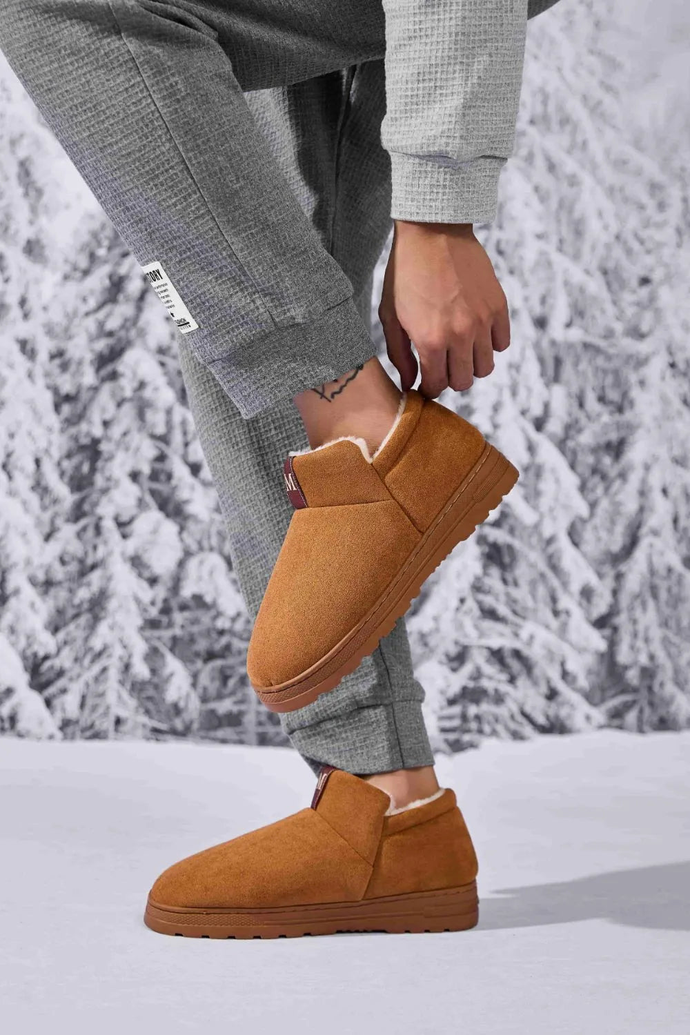 Caramel suede shearling-lined house booties with a slip-on design and rubber sole.