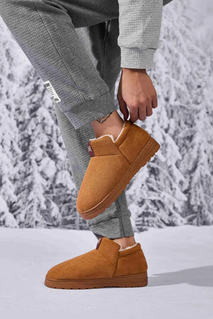 Caramel suede shearling-lined house booties with a slip-on design and rubber sole.