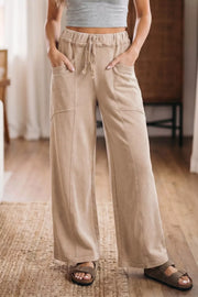 Mineral wash tan cotton wide leg maternity pants with drawstring waist and pockets.