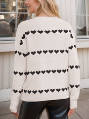 Ivory knit sweater with black heart stripes, crew neck, long sleeves.