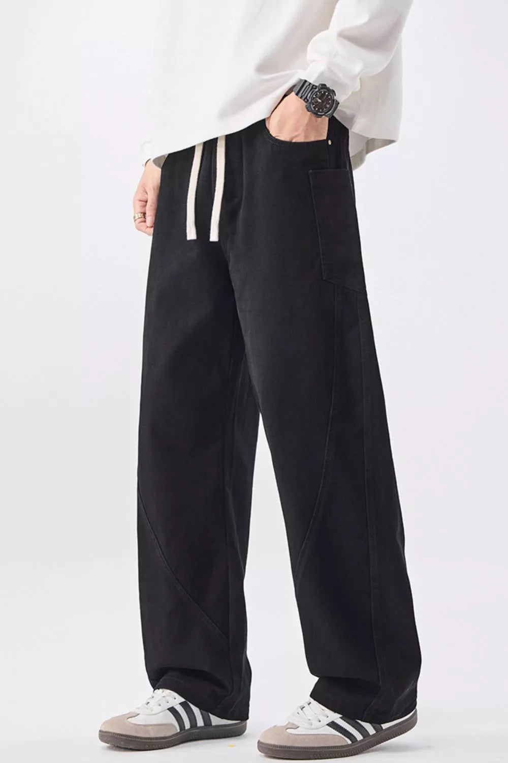Men's black relaxed fit cotton jeans with drawstring waist and casual styling.