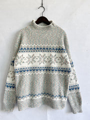 Geometric knit mockneck pullover with snowflake and chevron patterns in pastel colors.