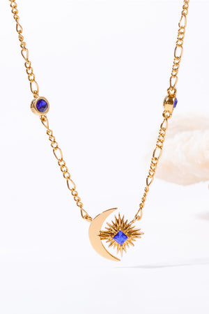 Gold celestial necklace with crescent moon, sunburst, and blue gems.