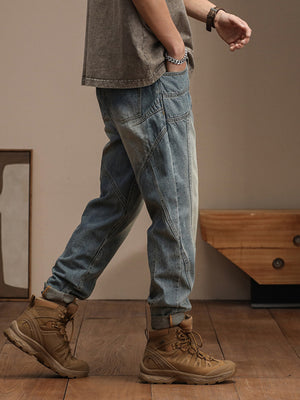 Relaxed fit vintage wash denim jeans with unique paneling and rolled cuffs.