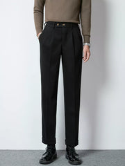 Men's black tailored pleated trousers with cuffed hems and double button closure.