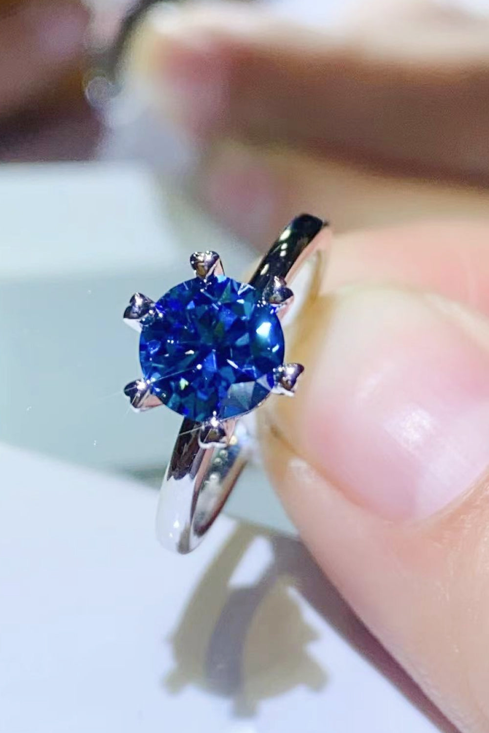 Blue moissanite ring with six-prong setting and silver band