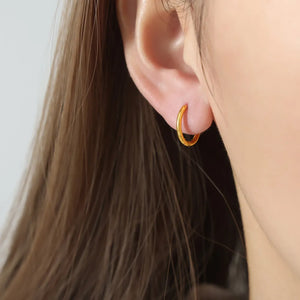 Minimalist gold vermeil huggie earrings in Style A, close-up on ear.