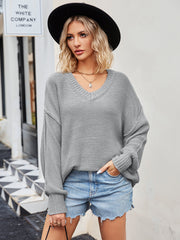 Oversized slouch knit v-neck sweater in grey acrylic with relaxed fit and ribbed cuffs.