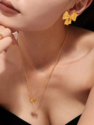 Gold bow jewelry set with sculpted detail, 18K gold necklace and earrings.