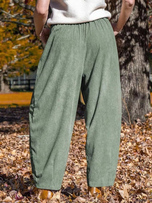 Sage corduroy wide-leg pants with pockets and an elastic waistband.