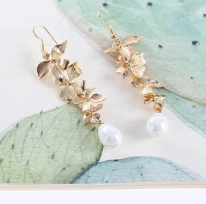 Gold cascading flower drop earrings with white pearls.