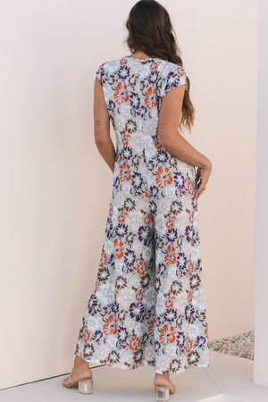 Floral cap-sleeve wide-leg jumpsuit with a light blue base and multicolor floral print.